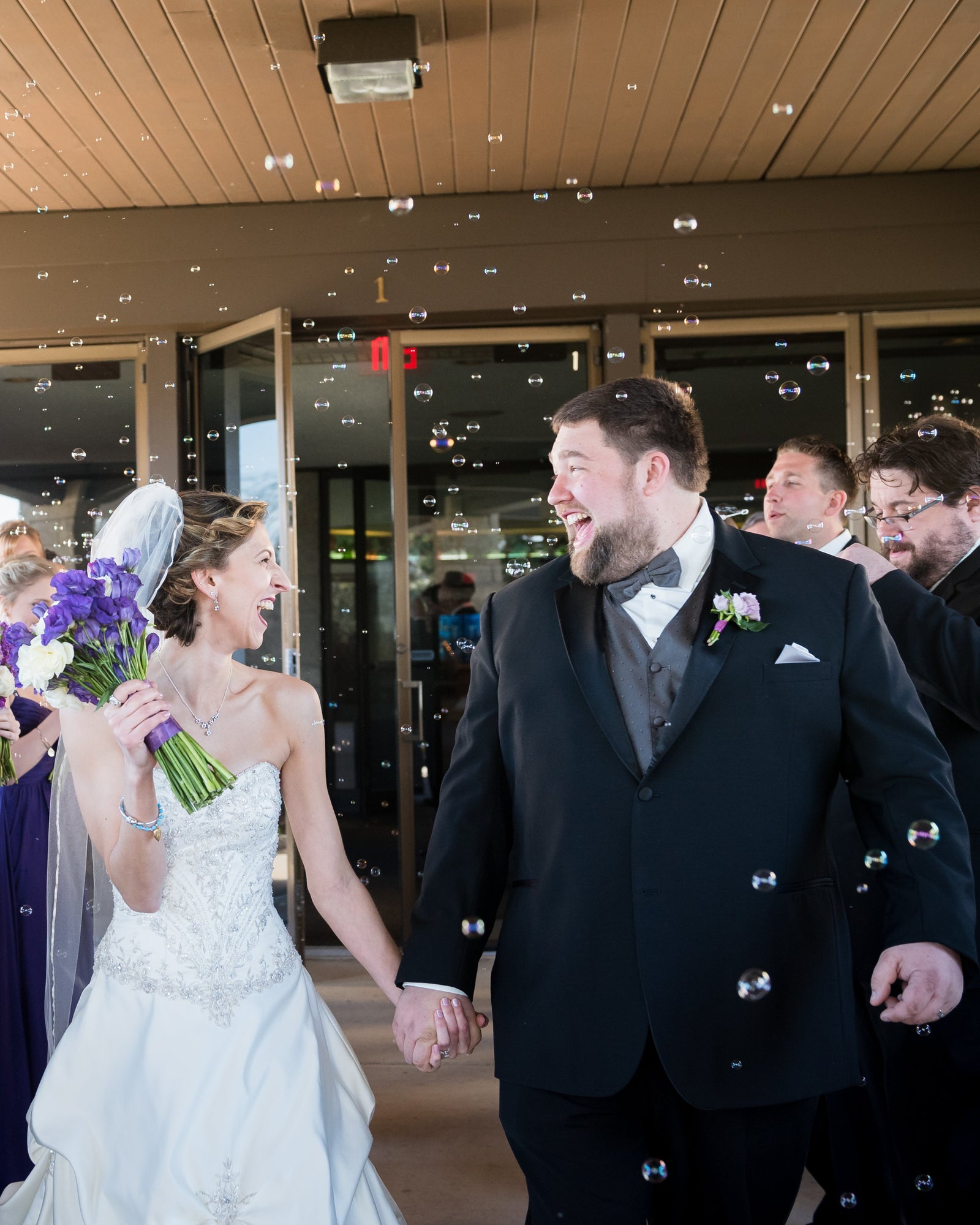 Wedding couple walking down an aisle with guests on either side.