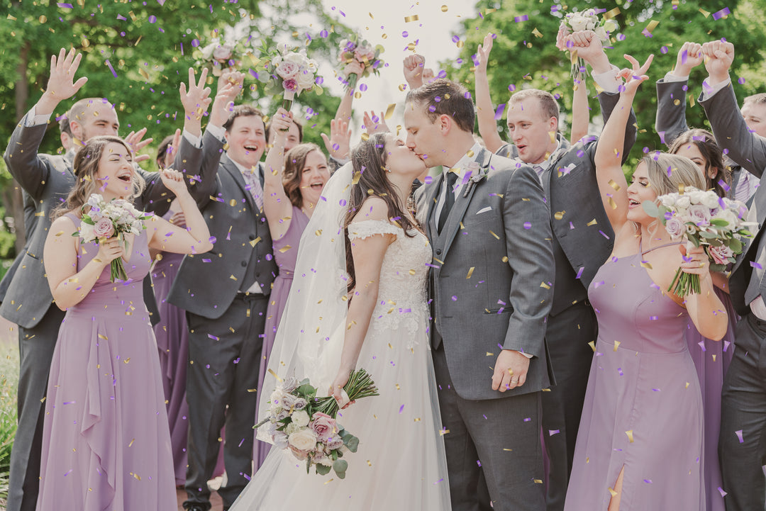 A man and woman sharing a passionate kiss during a celebration, with confetti falling around them.