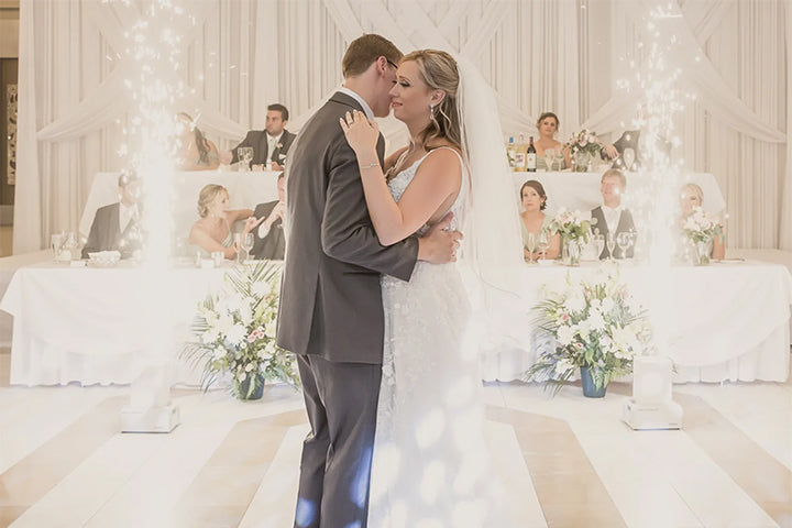 A bride and groom sharing their first dance in front of sparklers at their wedding.