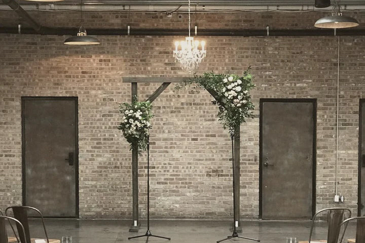 A wedding arch adorned with flowers and an elegant crystal chandelier, creating a romantic ambiance.