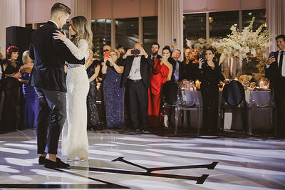 A bride and groom gracefully dancing on a vinyl monogrammed dance floor.